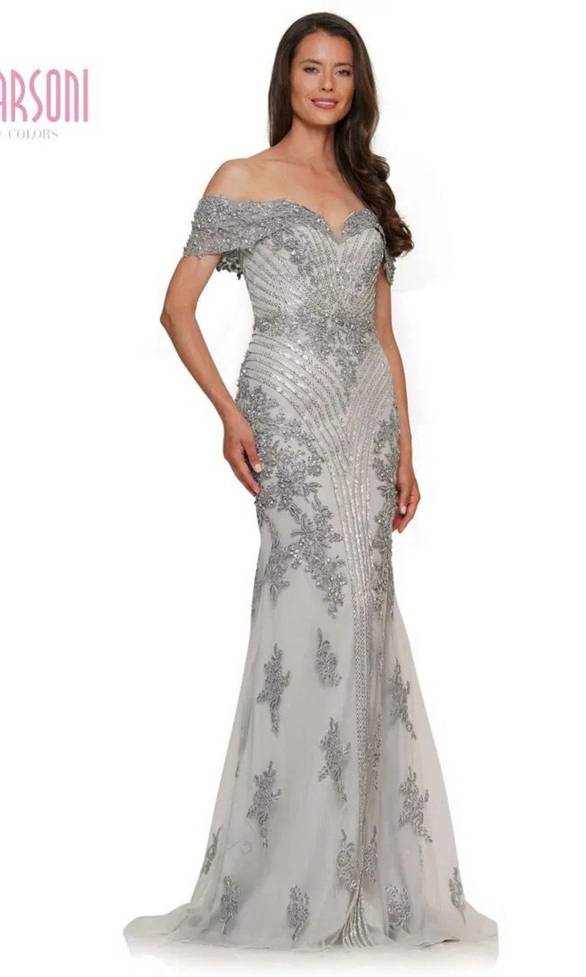 A woman models the Marsoni MV1275 long formal dress in silver, showcasing beaded detailing, an off-the-shoulder neckline, and a fitted bodice against a plain white background.